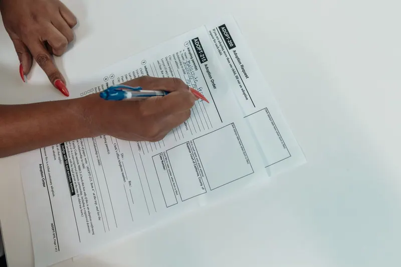 Hände vergleichen Papierunterlagen mit einem Stift